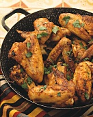 Crispy fried chicken wings with herbs in the pan