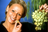 Blonde Woman Holding Bunch of Green Grapes