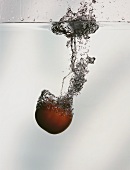A tomato falling into water