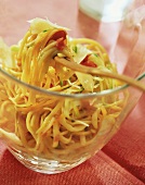 Linguine with vegetable strips in glass dish & on fork
