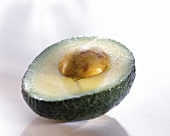 Avocado half with stone on a light background