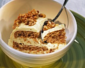A piece of buttercream cake with walnut kernels
