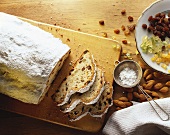 Butterstollen mit Puderzucker, daneben Zutaten