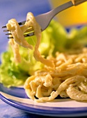 Home-made cheese noodles (spätzle) on fork and plate
