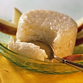 Apfel-Milchreis-Pudding, umgeben von Apfelspalten