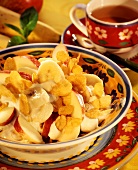 Fruit salad with yoghurt and flakes; teacup