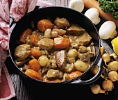 Lamb stew with onions and carrots in cast-iron pan