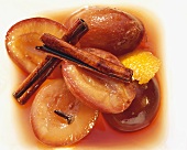 Plum compote with cinnamon sticks and orange peel