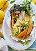 Fish in foil with carrots, pink pepper, lemon, coriander
