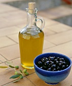 Olive oil and a bowl of black olives