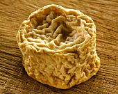 French Langres cheese on brown background