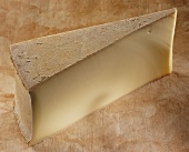 Beaufort, a French hard cheese, on a brown background