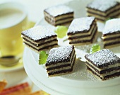 Black and white sweets with icing sugar on a plate