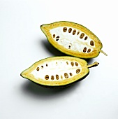 Two half cocoa beans on a white background