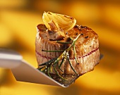 Pork fillet with sprig of rosemary on spatula