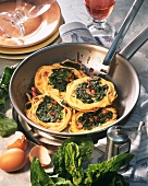 Fried spaghetti nests with spinach in a pan