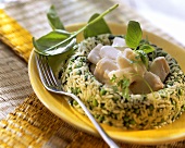 Fish stew in green rice ring with peas and herbs