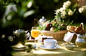 Table laid for breakfast with fruit, orange juice, coffee 
