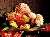 Geschnitzte Blüten aus Gemüse und Früchten in einer Schale