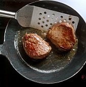 Frying fillet steak in iron pan