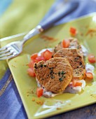 Curried veal fillet with tomato yoghurt on green plate