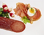 Open sandwich with sausage & egg; radishes; piece of sausage