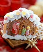 Gingerbread house with fairytale figures on red cloth