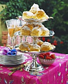 Etagere with profiteroles in open air; champagne; strawberries