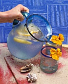 Limonade aus einem Krug in Gläser gießen