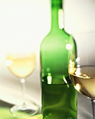 Weißwein in zwei Gläsern und grüner Flasche