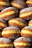 Viele Krapfen, mit Zucker bestreut (bildfüllend)