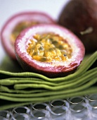 Halved passion fruits on green napkins