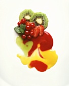 Kiwi fruits, strawberries and redcurrants with fruit sauces