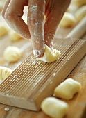 Making potato gnocchi: shaping on wooden board