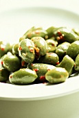 Green olives with chili on white plate