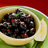 Bottled black olives in a yellow bowl