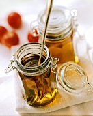 Tomato consommé in preserving jars; tomatoes