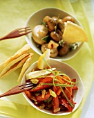 Marinated vegetables and mushrooms in white bowls