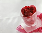 Raspberry sorbet with fresh raspberries in glass