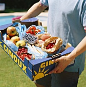 Man carrying bought fruit and vegetables in a crate