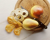 Apple and pear, fresh and dried, on a wooden plate
