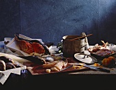 Mediterranean fish on & beside chopping board; saucepan