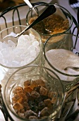 White & brown sugar and crystal sugar in glass bowls