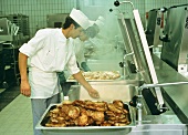 Chef frying meat in the kitchen of an industrial company