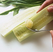 Hollowing out peeled cucumber with a spoon