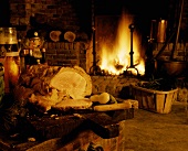 Roast pork in bread dough on wooden board in front of fire