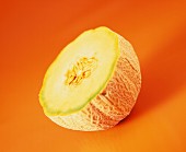 Half a musk melon on brown background