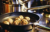 Sautéing meatballs in frying pan
