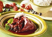 Berry pudding with cream on plate, ingredients behind