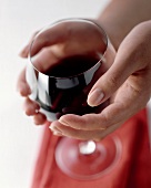 Warming red wine in the glass with the hands